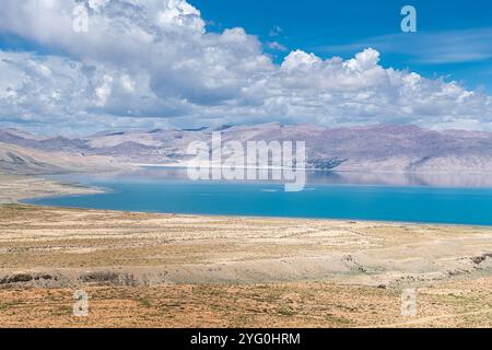 The sacred Manasarovar lake with blue transparent water in the mountains of Tibet under cloudy sky. Ngari scenery in West Tibet. Sacred place for Budd Stock Photo