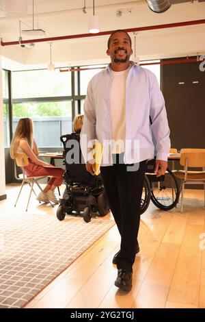 Businessman walking through office Stock Photo
