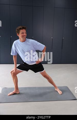Smiling man stretching in gym Stock Photo