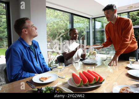 Friends enjoying pizza at table Stock Photo