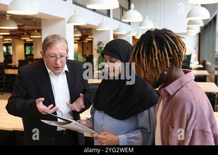 Two businessmen and businesswoman discussing in office Stock Photo