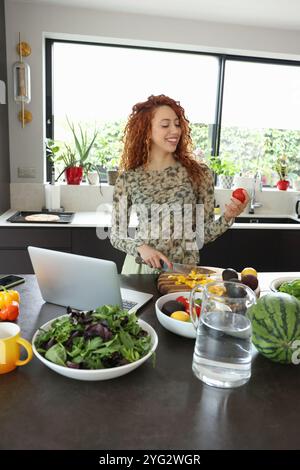 Woman cutting vegetables in kitchen Stock Photo