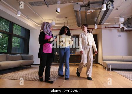 Diverse group of businesswomen walking through office Stock Photo