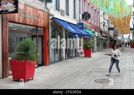 Waitress & Street Scene along Main Shopping Street, rue Brauhauban, in the Old Town or Historic District Tarbes Hautes-Pyrénées France Stock Photo