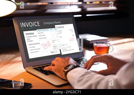 Man using laptop to pay bills at home, closeup Stock Photo