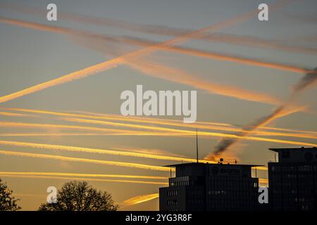 Condensation trails from aircraft flying at high altitude, evening sky, after sunset Stock Photo