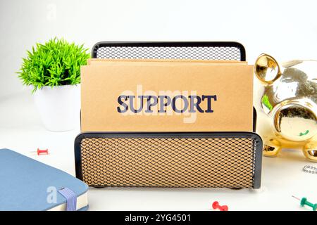 Business concept. The phrase, the text, the words SUPPORT are written on paper in a black stand on a light background. Stock Photo