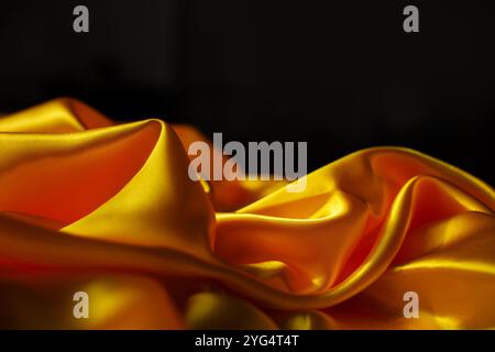 Yellow silk satin. Draped fabric. golden color. Luxury background Stock Photo