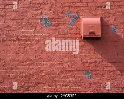 distressed red brick wall with vent Stock Photo