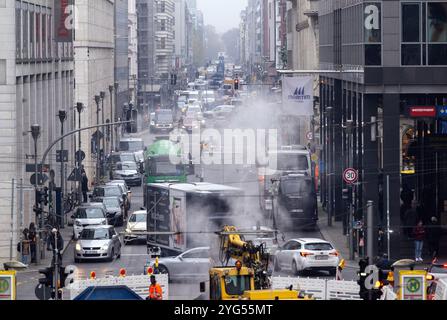 Berlin, Germany. 06th Nov, 2024. Vehicles are stuck in a traffic jam on Friedrichstrasse, with the light gray smoke of a road construction site on the corner of Dorotheenstrasse rising in the foreground. Numerous streets in the city center are closed due to the celebrations to mark the fall of the Berlin Wall. Credit: Soeren Stache/dpa/ZB/dpa/Alamy Live News Stock Photo