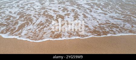 A panoramic image of the sea slowly creeping in on a beach in Cornwall in the UK. Stock Photo