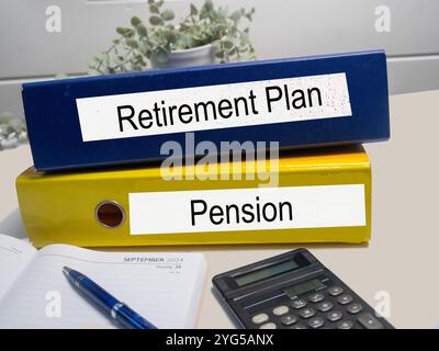 Two colored ring binders with the words Pension, Retirement, in an office Stock Photo