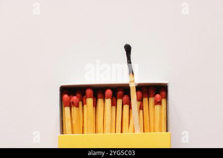 One burnt match among the whole ones. Scattered wooden matches without a box close-up. Design Stock Photo