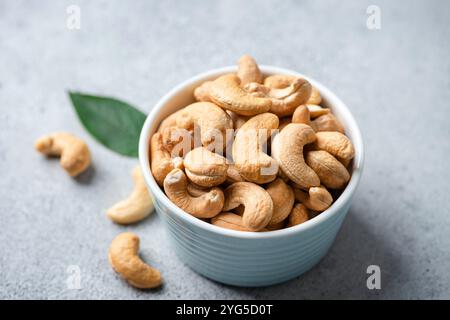 Roasted cashew nuts in a bowl on concrete table background, closeup view Stock Photo