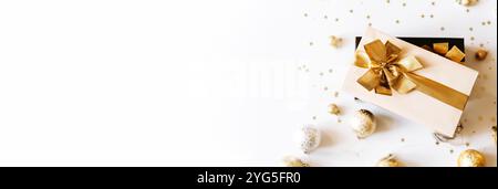 Two Christmas gift boxes, adorned with vibrant golden ribbons on white background with shadows. Flat lay. Copy space. Christmas or New year banner Stock Photo