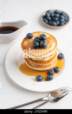 Stack of pancakes with blueberries and maple syrup on white plate. Breakfast meal Stock Photo