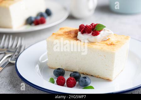 Cottage cheese casserole Zapekanka served with raspberries, blueberries and whipped cream. Sweet and healthy breakfast cake which is rich in calcium a Stock Photo