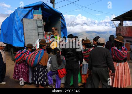 Aymara women wearing traditional dress and other local people buying goods from a truck in the street, Coroico, Yungas region, Bolivia Stock Photo