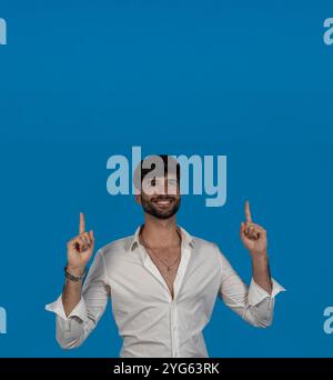 young man pointing upward with his index fingers Stock Photo