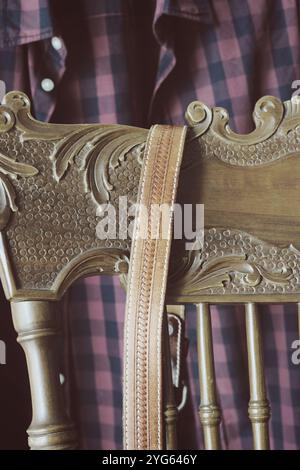 male checked shirt and leather belt hanging on chair Stock Photo