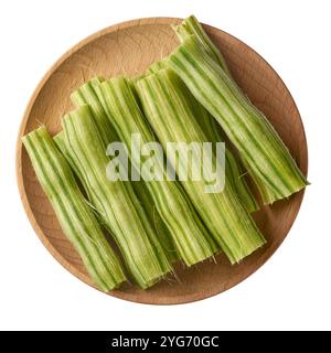 pieces of peeled moringa or drumstick on wooden tray isolated white background, highly nutritious superfood vegetable ready for cooking in curries Stock Photo