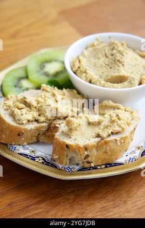 Plate with home made tempeh pate in a bowl and on two slices of bread. Stock Photo