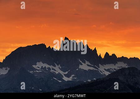 orange sunset clouds behind the spires of the minarets mountains near Mammoth Lakes California Stock Photo