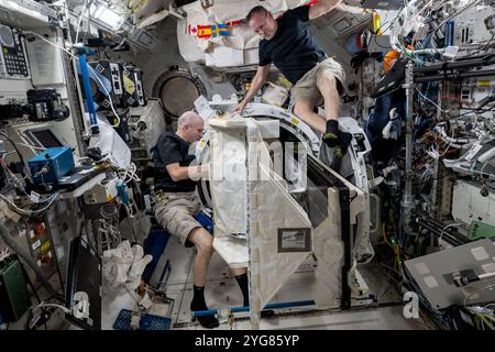 International Space Station, Earth Orbit. 30 October, 2024. NASA astronauts and Expedition 72 Flight Engineers Butch Wilmore, right, and Don Pettit, left, remove a small satellite deployer from inside the Kibo laboratory module airlock aboard the International Space Station, October 30, 2024 in Earth Orbit. Earlier they deployed several CubeSats into Earth orbit for a series of technology studies. Credit: Astronaut Provided/NASA/Ģ����ý Live News Stock Photo