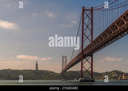 Portugal's 25 de Abril suspension bridge spanning the Tagus River estuary in the city of Lisbon and the National Shrine of Christ the King, Europe Stock Photo