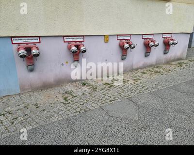 Row of fire department connections (FDCs) on the wall of a building Berlin, Germany, with text Löschwassereinspeisung; firefighting Stock Photo