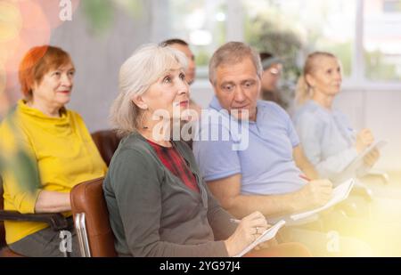 Group of older students sitting and listening at lesson Stock Photo