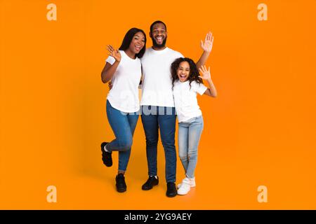 African American family waving hands at camera at studio Stock Photo