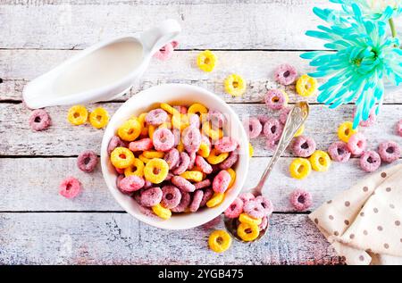 Falling colorful corn rings in bowl on white table Stock Photo