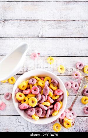 Falling colorful corn rings in bowl on white table Stock Photo