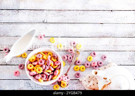 Falling colorful corn rings in bowl on white table Stock Photo