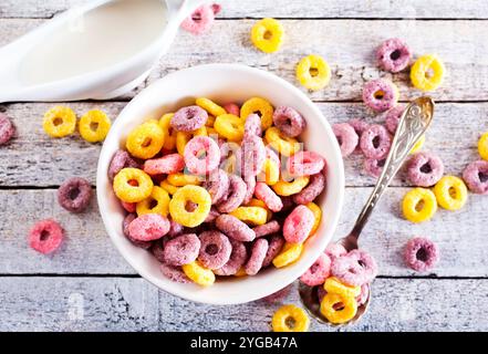 Falling colorful corn rings in bowl on white table Stock Photo