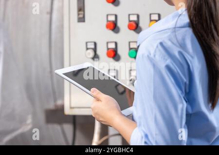 Engineer using Tablet software check service maintenance electricity main circuit fuse and power system in industry factory Stock Photo