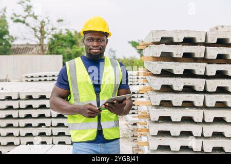 Black African construction male worker, Foreman standing happy smiling outdoor at construction site Stock Photo