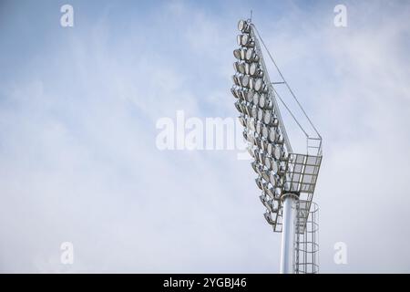 Stadium large high power lighting, Floodlights over a sports field outdoors against blue sky. Stock Photo