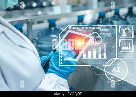 Modern worker using computer tablet AI application software on handheld device help control operating drinking water factory plant. Stock Photo