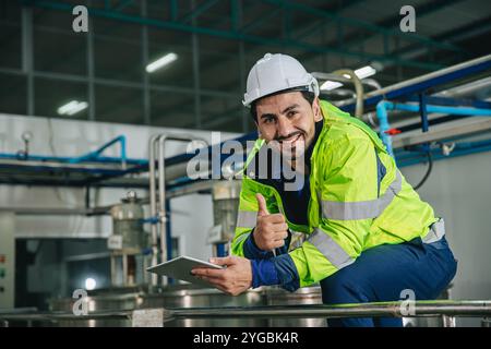 Portrait of satisfied happy smiling factory manager. Engineer wearing safety vest standing service worker in boiler tank room. Stock Photo