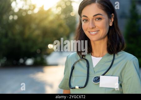 Pretty young female doctor looking thoughtful in the light of morning sun Stock Photo