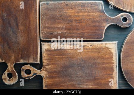 Three old retro cutting boards of various shapes on wooden background, close up Stock Photo