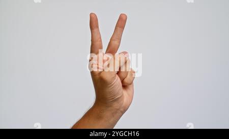 Man hand making victory gesture on plain white background showing peace sign Stock Photo