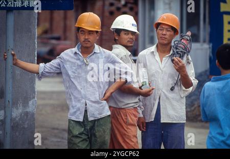 China, Beijing, construction workers in front of a  housing project. Stock Photo