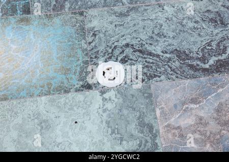 Exquisite Textured Stone Floor Featuring a Stylish Circular Drain Cover in its Design Stock Photo