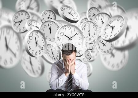 Stressed person overwhelmed by time pressure with clocks in background Stock Photo