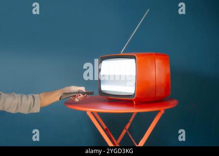 person changes channels on tv with remote control, concept of power Stock Photo