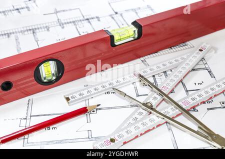 Spirit level, pencil, yardstick and compass calipers on a construction plan Stock Photo