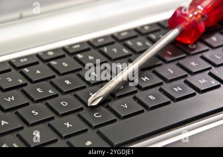Screwdriver on computer keyboard symbolizing IT maintenance Stock Photo
